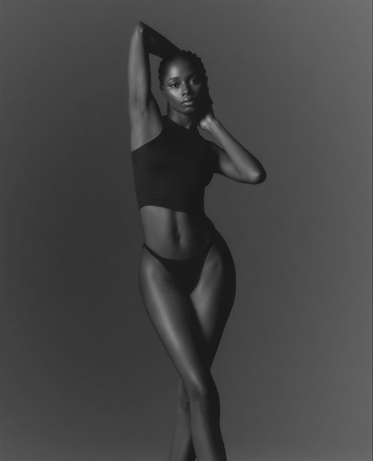 Black-and-white studio portrait with a defined waist and hip silhouette